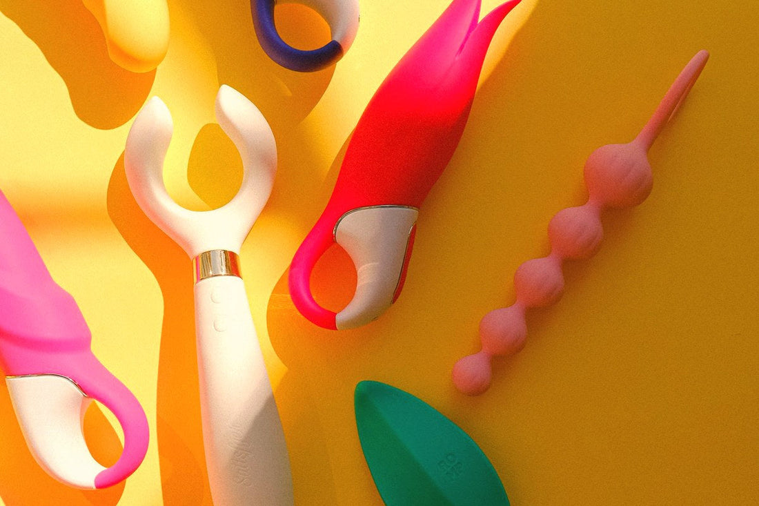Colorful silicone sex toys arranged on a yellow background, benefits of silicone based adult toys