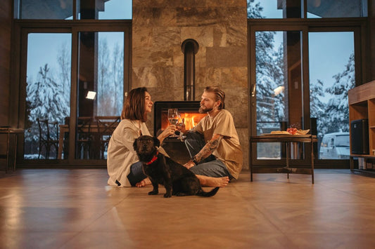 Couple sitting by a cabin fireplace with their dog on a snowy night, a cozy romance story