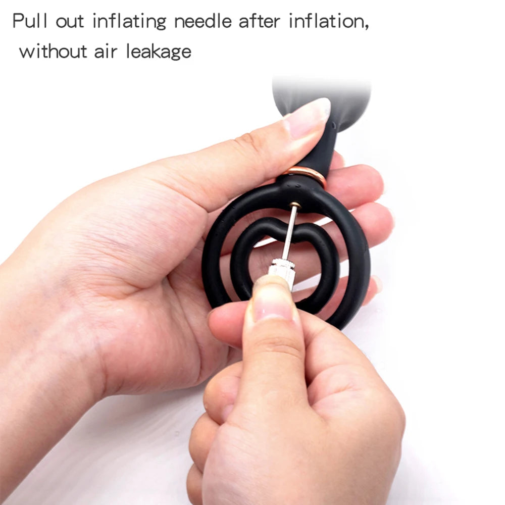 Hand holding an inflatable object with a needle being pulled out, on a white background.
